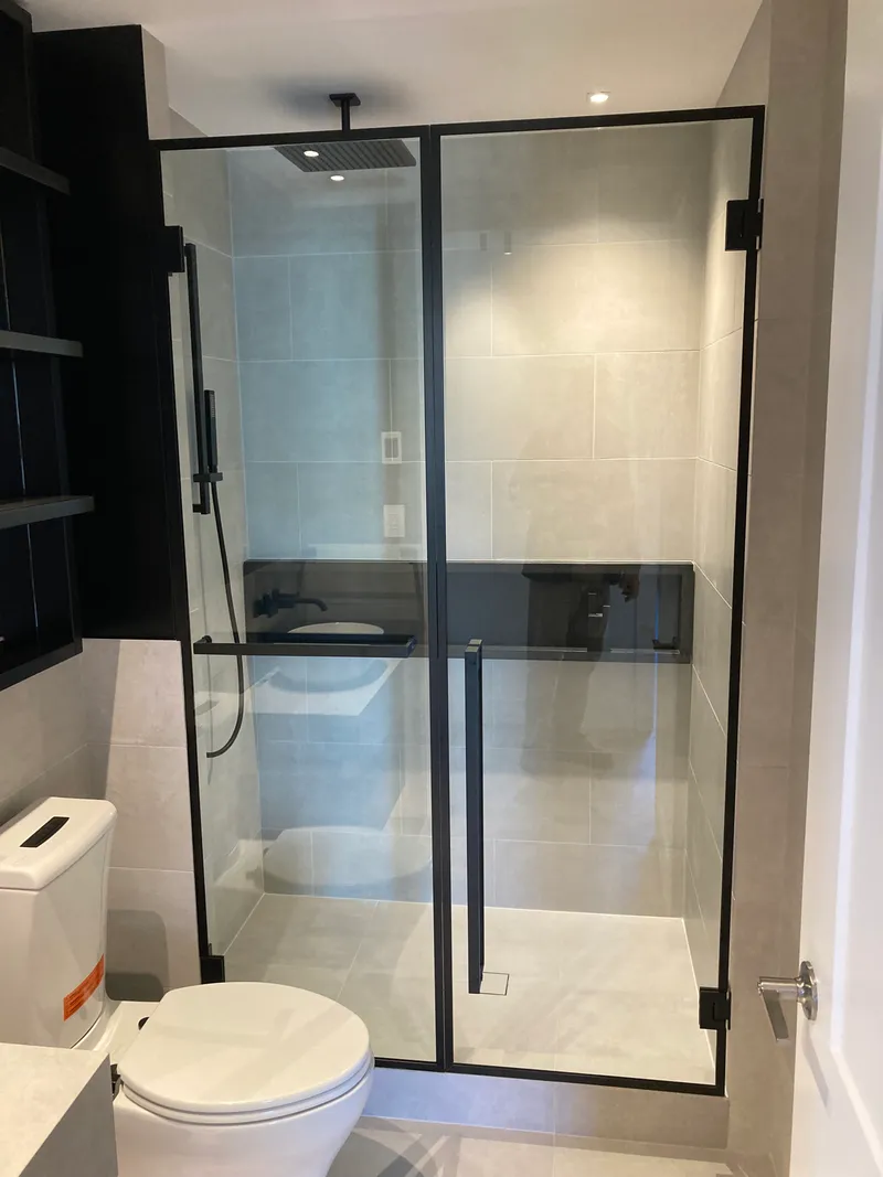 Frameless shower enclosure with matte black hardware in Vancouver